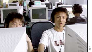 Chinese young men surf the internet at a cyber cafe in Shanghai, 18 June 2002.