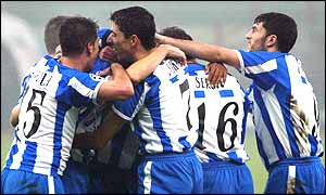 Deportivo La Coruna mob goalscorer Roy Makaay (hidden) after his strike puts them through to the second phase