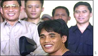 Bali suspect Amrozi smiles for the media