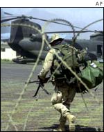 US soldier from the 101st Airborne walks past a Chinook helicopter