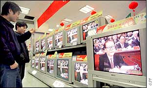 Chinese shopper watch Jiang Zemin on TV as he addresses the closing session of the 16th Communist Party Congress