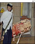 Jewish settler carries blood-stained stretcher