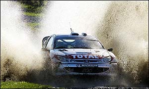 Frenchman Gilles Panizzi drives his Peugeot 206 out of the water splash during the Margam Park special stage
