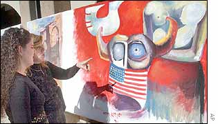 An Iraqi woman explains to her daughter look at a painting expressing anti-U.S ideas at Saddam Art Centre in Baghdad,.
