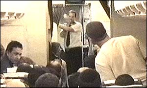 Footage from El Al plane showing steward speaking on intercom as passengers look on