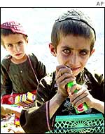 Afghan boys sell sweets by a roadside