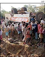 Villagers gather around the overturned bus after Tuesday's landmine blast in Andhra Pradesh