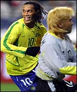 Ronaldinho celebrates past South Korean goalkeeper Kim Byung-Ji after scoring a penalty