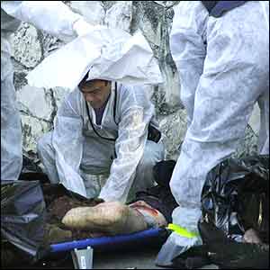 Forensic experts examine the body of a victim