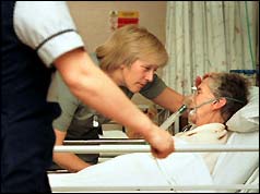 Two nurses at the bedside of an elderly patient