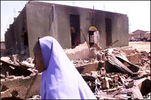 Muslim woman next to ruined building 