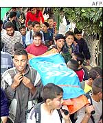 A symbolic stretcher with the UN flag, carried by Palestinian's marking Mr Hook's death