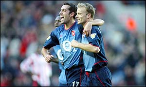 Dennis Bergkamp celebrates his goal for Arsenal with team-mate Edu