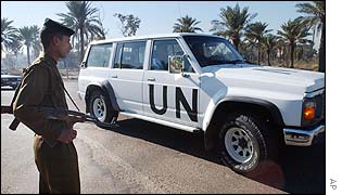 Iraqi soldier watches UN vehicle pass