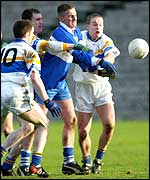 Ballinderry's John Conway gets the ball away despite pressure