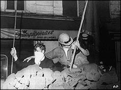 Two students kiss behind a barricade in May 1968