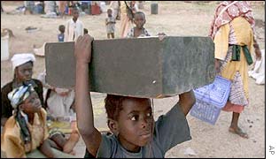 Displaced people carry belongings to a camp in Kaduna