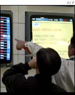 Passengers look at empty destination boards at Roissy airport