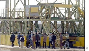 Weapons inspectors examine a metal structure in Iraq