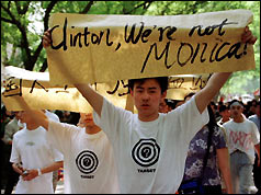 A chinese student holds up a placard aimed at President Clinton - "Clinton, we're not Monica"