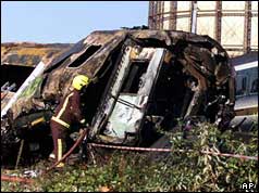 Fireman hoses down a wrecked carriage after the Paddington crash