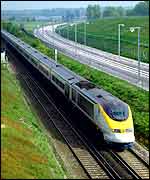 Eurostar train runs beside road, PA
