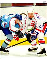 Two players challenge for the puck