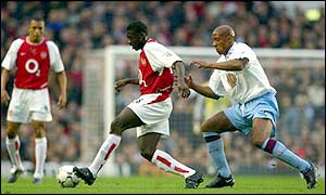 Villa striker Dion Dublin tries to tackle Arsenal's Kolo Toure