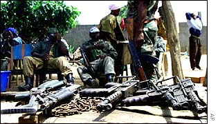 Rebel soldiers with a pile of weapons in Ivory Coast