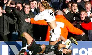 Diego Forlan celebrates his first goal, while Jerzy Dudek flounders in his misery