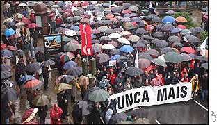 Protesters in Santiago march behind banner reading No more
