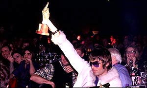 Liam Gallagher holds up an award during the 2001 NME Carling Awards