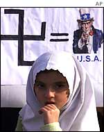 A Turkish girl stands in front of an anti-American poster