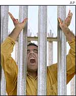 A male refugee, cries out moments before a breakout from the Woomera Detention Centre in Outback Australia, Friday, March 29, 2002.