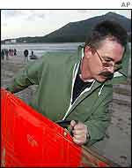 Portuguese Navy worker helps put in place an oil barrier