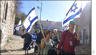 Israeli settlers walk through Hebron, a town in the West Bank