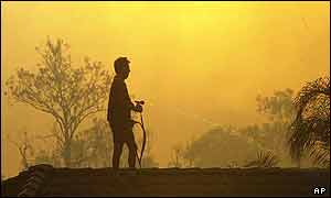 Resident of Wattle Grove suburb wets the roof of his house