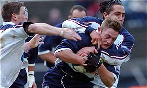 Bristol's David Rees is hauled down by Gavin Henson with help from Scott Gibbs