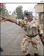 An Iraqi soldier clears journalists from a UN inspection of a plant in Samarah