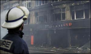 A firefighter observes the burnt-out shell of a building on Edinburghs South Bridge 