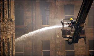  firefighter trains his hose on the burnt-out shell of a building in Edinburghs Cowgate 