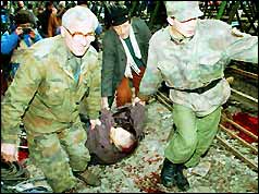 Photo of an injured man being helped by soldiers