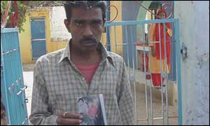 A man with a picture of his son who was killed in the rioting earlier this year 