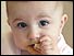Head shot of 6 month old baby eating a rusk