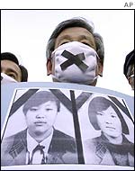 Protestor with photos of the dead girls