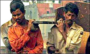 Workers carrying steel in Chittagong shipbreaking yard