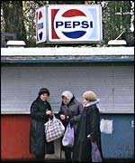 Women walking past Pepsi kiosk