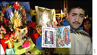 A man shows pictures of the Virgin of Guadalupe for sale