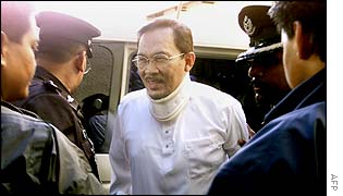 Malaysian former Deputy Prime Minister Anwar Ibrahim (centre) is escorted by police officers as he arrives at the General Hospital in Kuala Lumpur, Malaysia, 13 Dec 2002. 