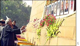 Prime Minister Atal Behari Vajpayee throws flower petals in front of the portraits of security personnel killed during the attack